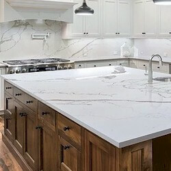 White background with bold, dynamic light grey and gold veining island countertop.