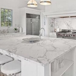 Bright white background with gray veining marble large kitchen island.