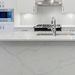 Luminous white background with bold, dynamic blue-grey veining countertop surfaces with waterfall.