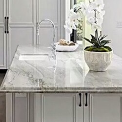 Luminous white background with large, flowing black veining quartzite kitchen island.