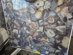 Deep smoky grey tones with swirling banded agate patterns and crystalline centers; can be backlit for dramatic effect