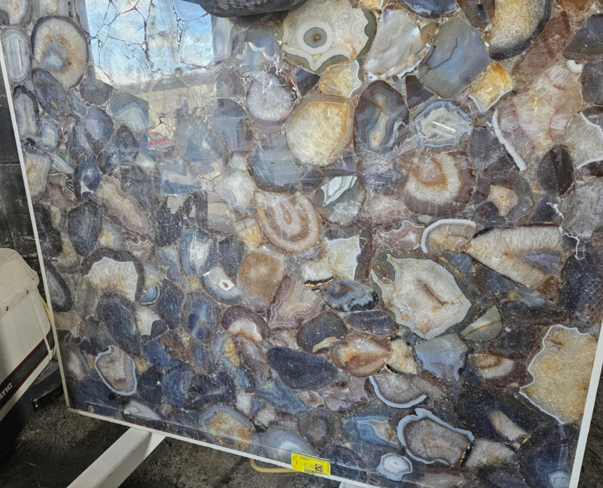Deep smoky grey tones with swirling banded agate patterns and crystalline centers; can be backlit for dramatic effect