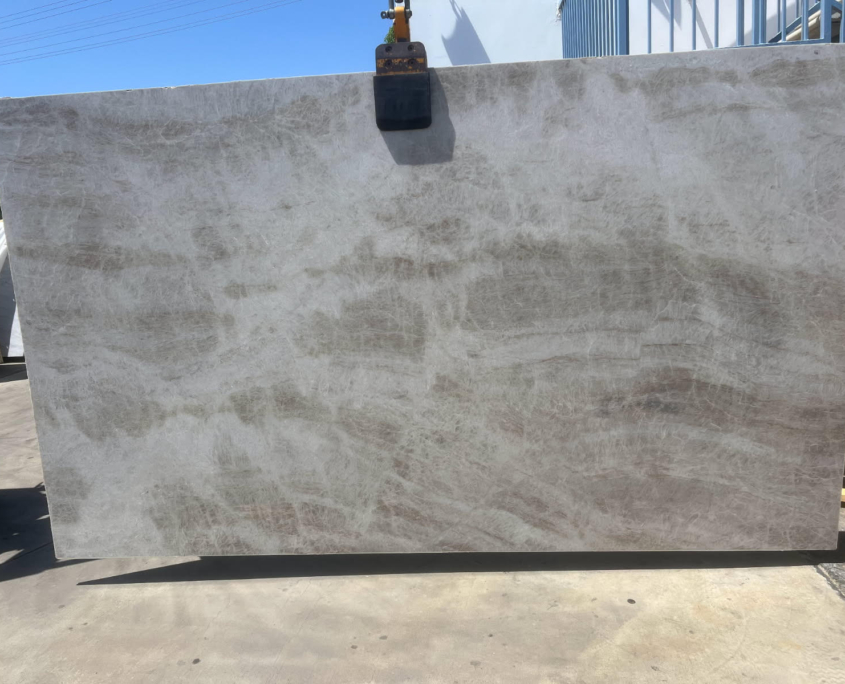 It’s a natural quartzite that has a creamy tan/white background with subtle gold / brown / rust veining.